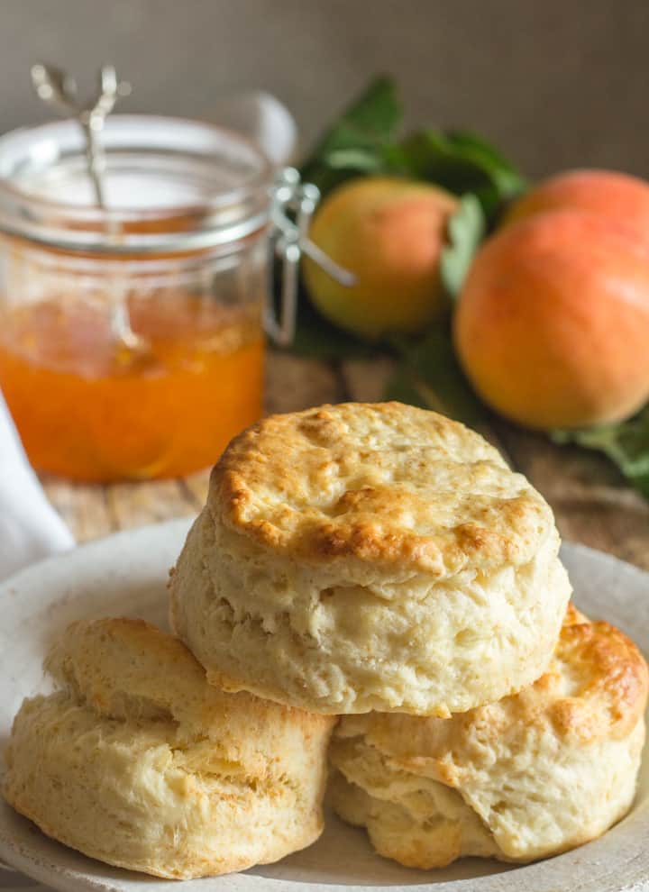 3 biscuits on a plate with apricots and jam
