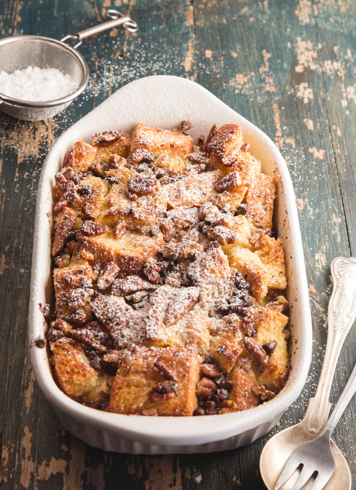 the bread pudding in the baking dish baked and sprinkled with powdered sugar