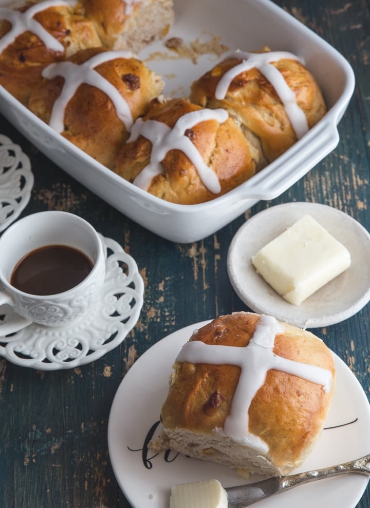 buns on a plate and in the baking pan with a cup of coffee