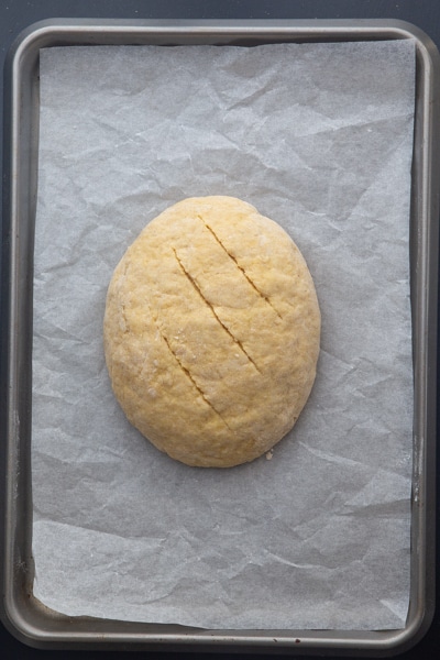 the dough shaped and scored on a parchment paper lined cookie sheet