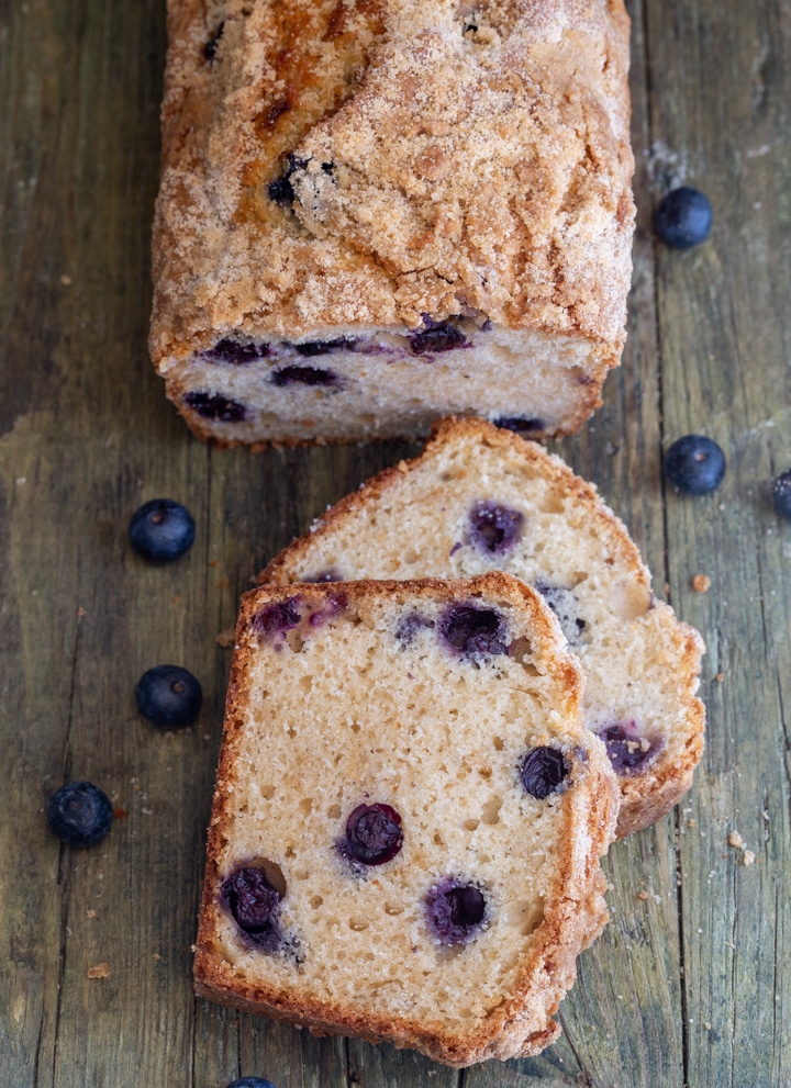 blueberry bread with 2 slices cut on a board