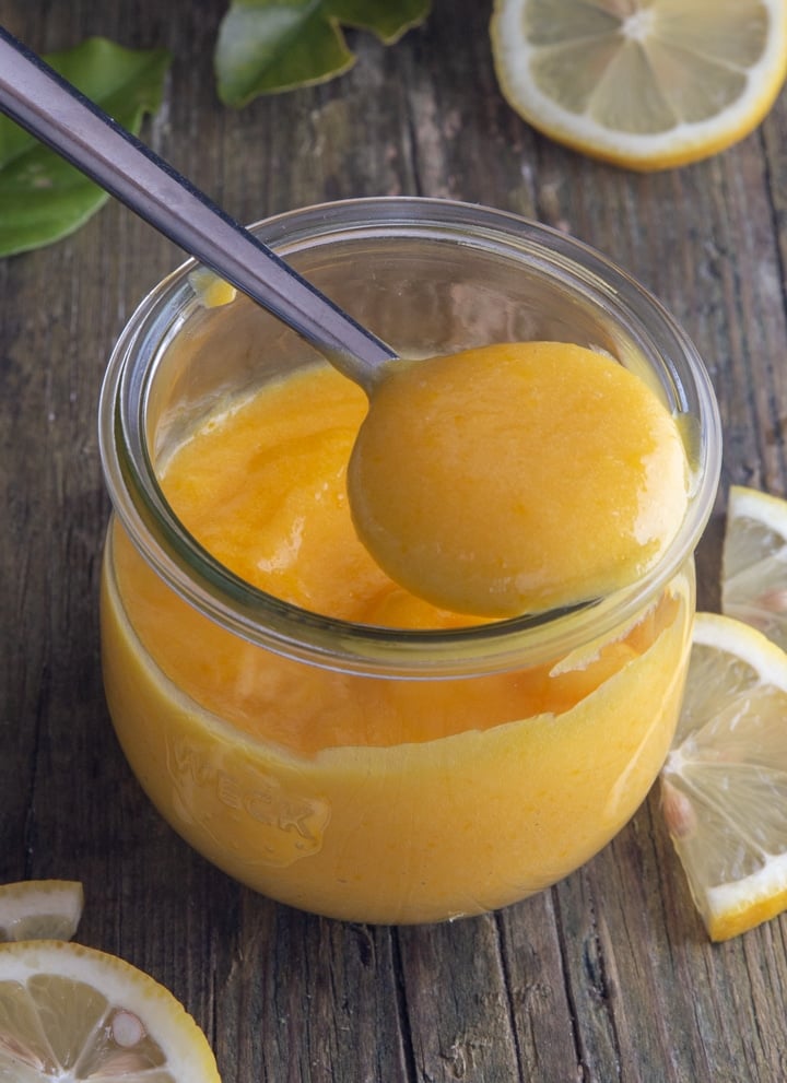 lemon curd on a spoon over the jar.