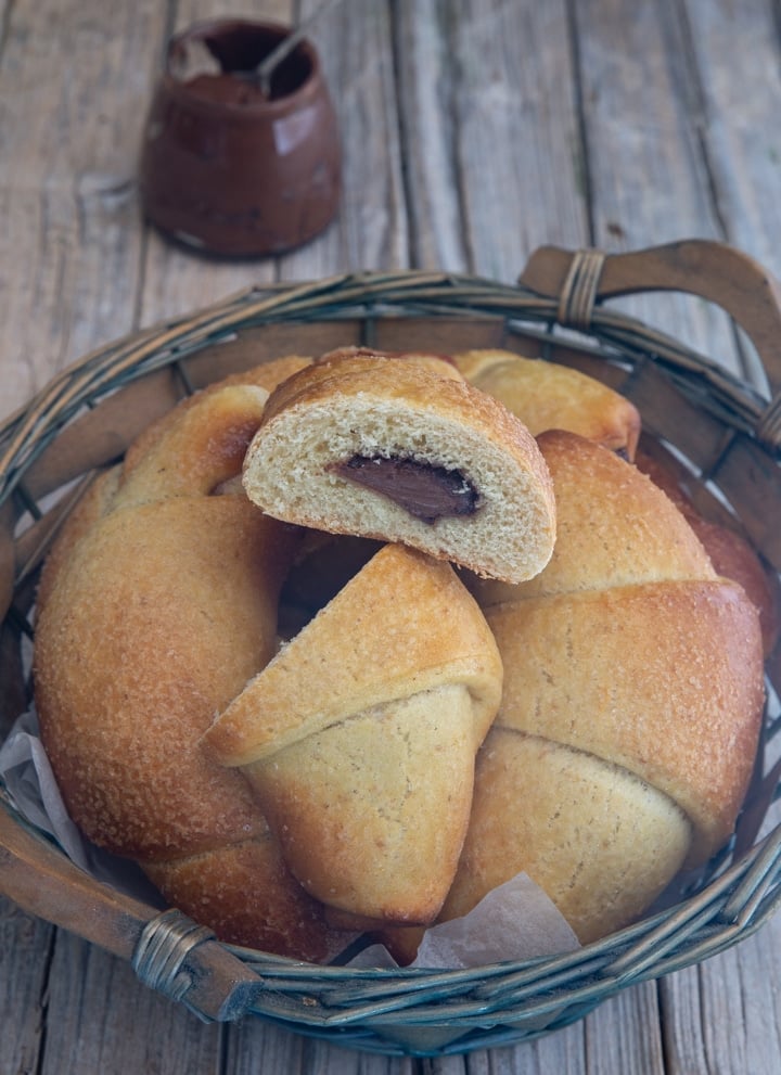 crescents in a blue basket with one cut in half.