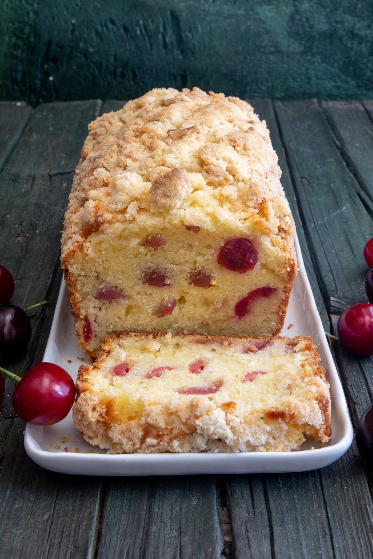 Cherry bread on a white plate with a slice cut.