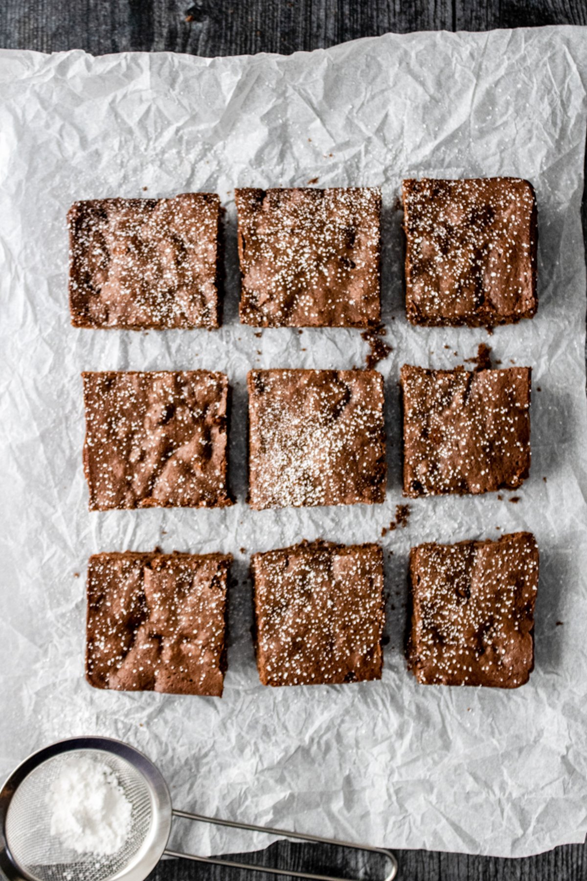 9 cut brownies on parchment paper.