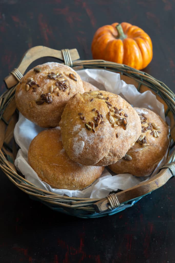 Pumpkin bread buns in a blue basket.