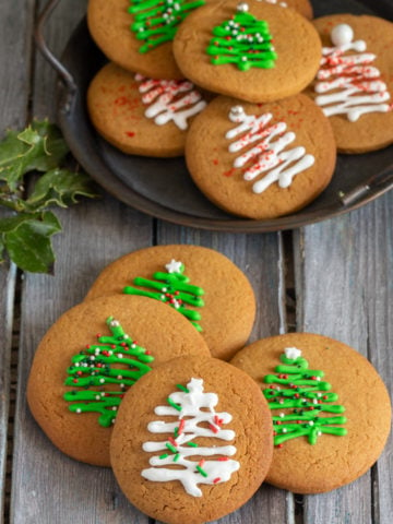 Gingerbread cookies on a black plate and 4 on a grey board.