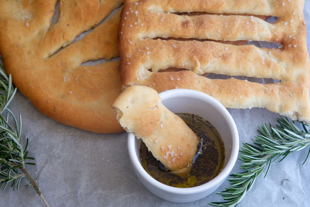 fougasse with a piece in the dipping sauce.