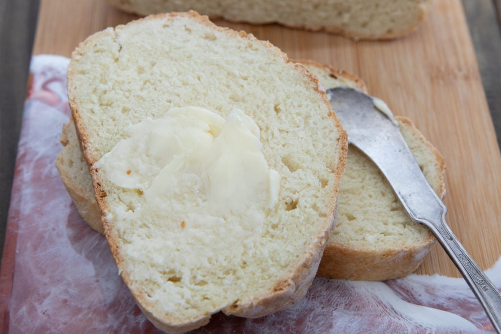 A slice of Irish soda bread with butter spread on top.