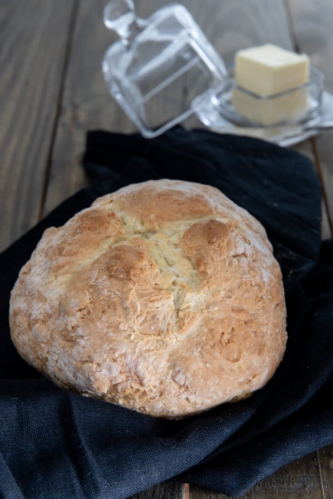 Irish soda bread load on a black napkin with butter in a glass container
