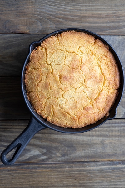 The baked cornbread in a black pan.