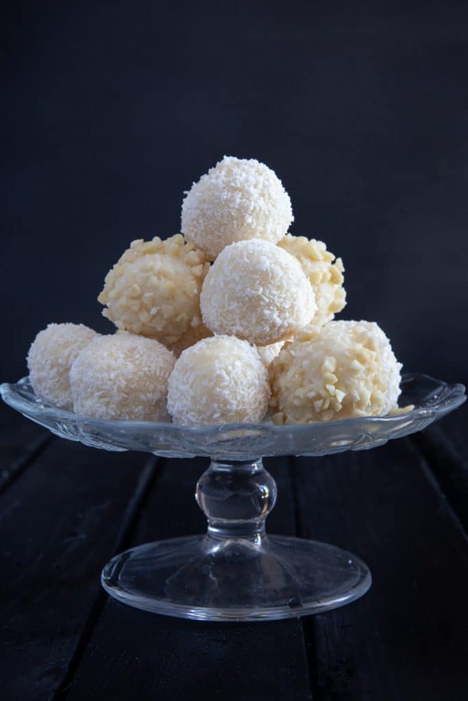 Coconut white chocolate truffles on a glass stand.