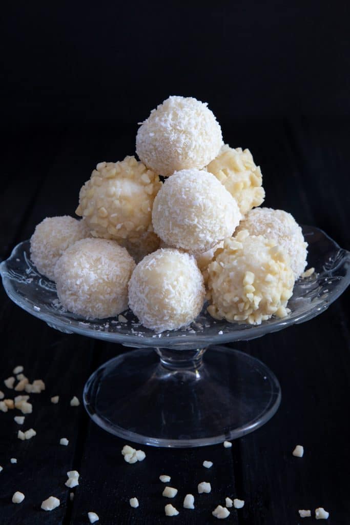 Coconut white chocolate truffles on a glass stand.