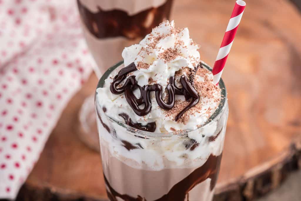 Milkshake in a glass with whipped cream.