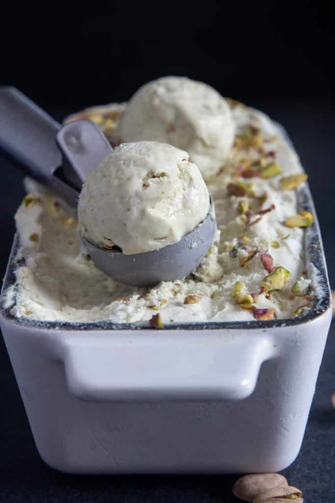 Pistachio ice cream with 2 scoops in a loaf pan.