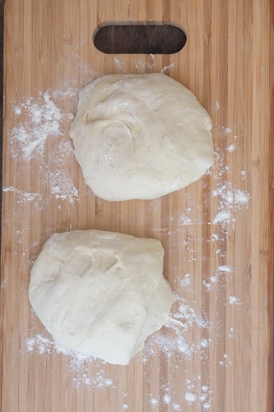 Dividing the dough in half on a wooden board.