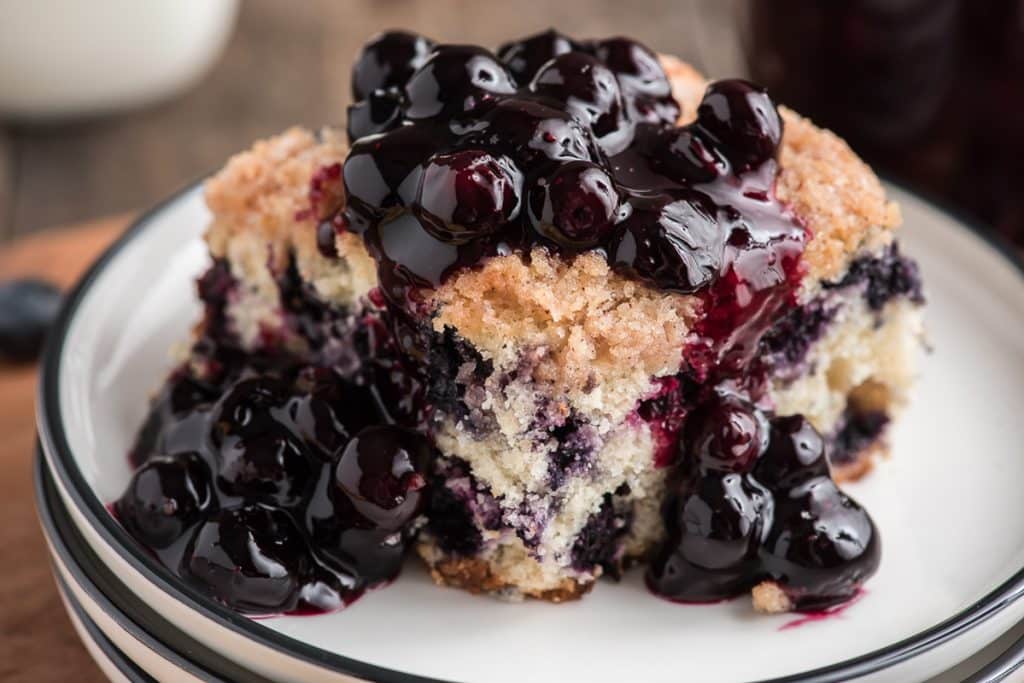 a slice of blueberry buckle on a white plate.