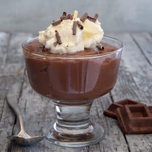 chocolate pudding in a dish with whipped cream.