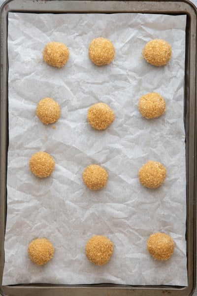 Dough rolled into balls on a cookie sheet.
