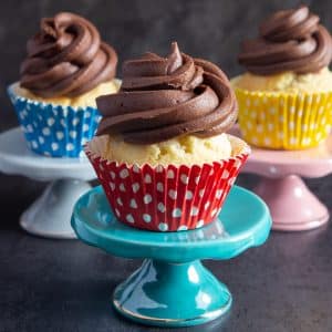 three cupcakes on three different cake stands.