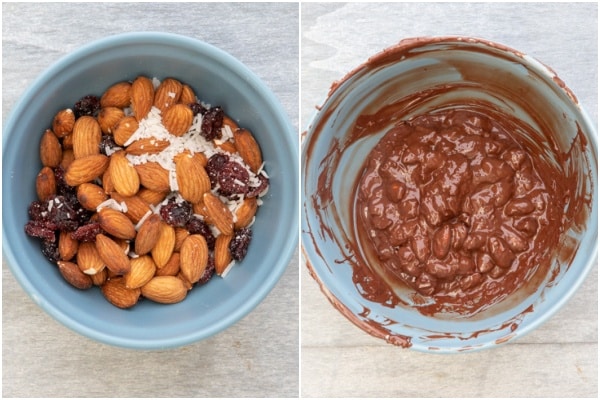 The nuts, cranberries and coconuts mixed and mixed with melted chocolate in a blue bowl.