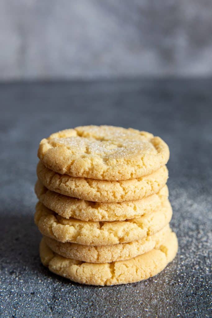 Stacked crunchy cookies with granulated sugar sprinkled around.