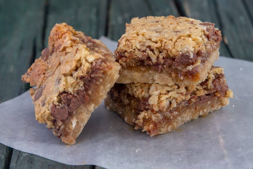 Three nut bars on top of a piece of parchment paper.