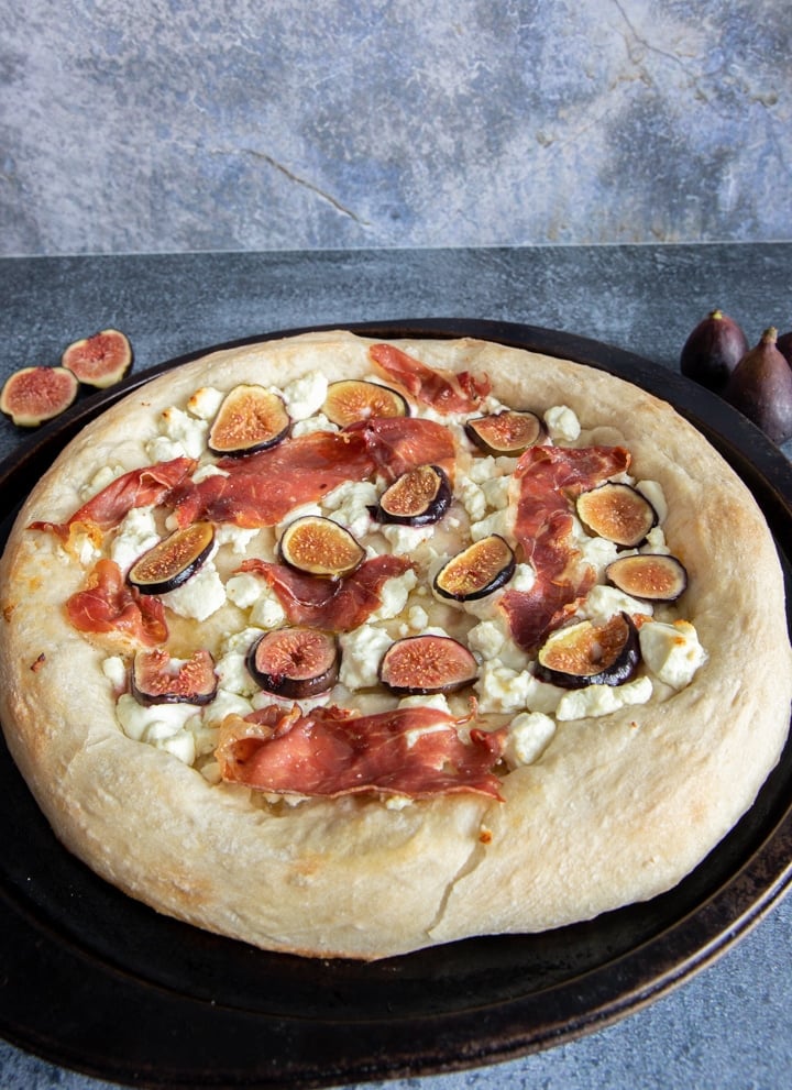 Round Pizza on a black pan.