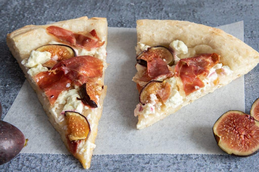 Two slices of pizza on a piece of parchment paper.