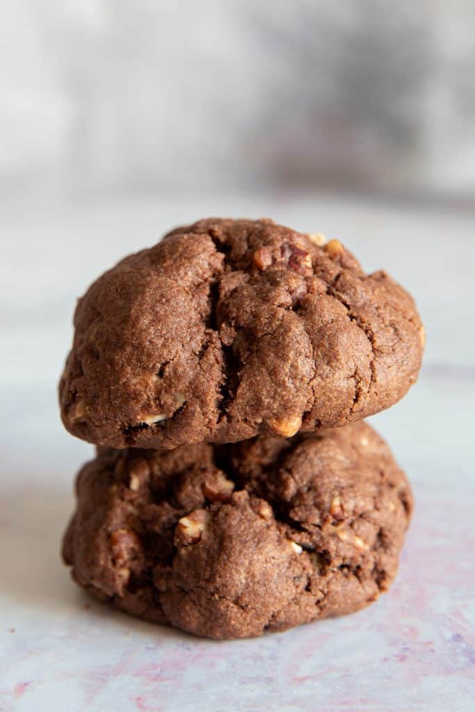 Two pecan cookies one on top of each other.