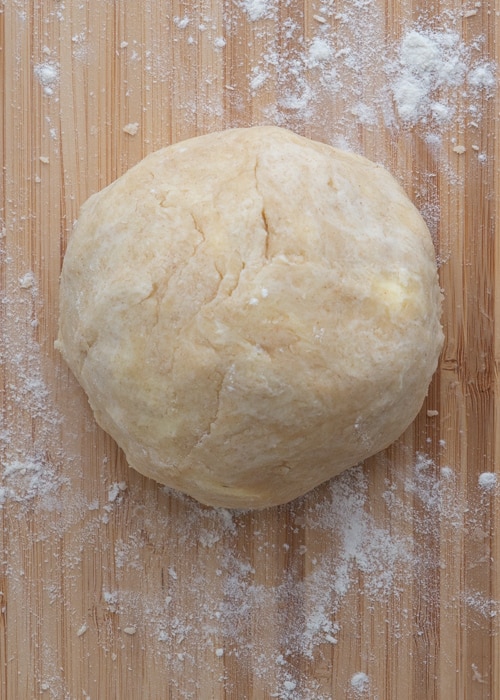 Dough ball on wooden board before chilling.