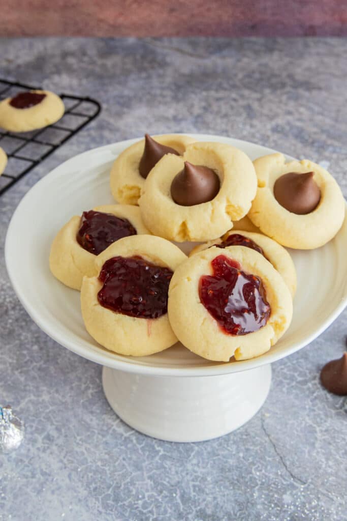 Thumbprint cookies on a white cake stand.