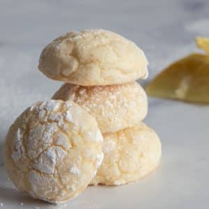 Three lemon cookies on top of each other and one more cookie leaning on them.