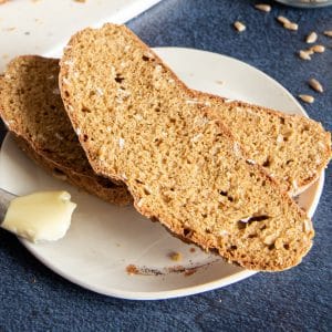 Two slices of irish brown soda bread on a white plate.