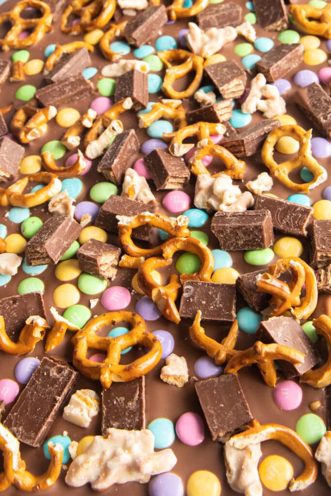 Chocolate bark covered in pretzels, kit kat pieces, smarties and clusters.