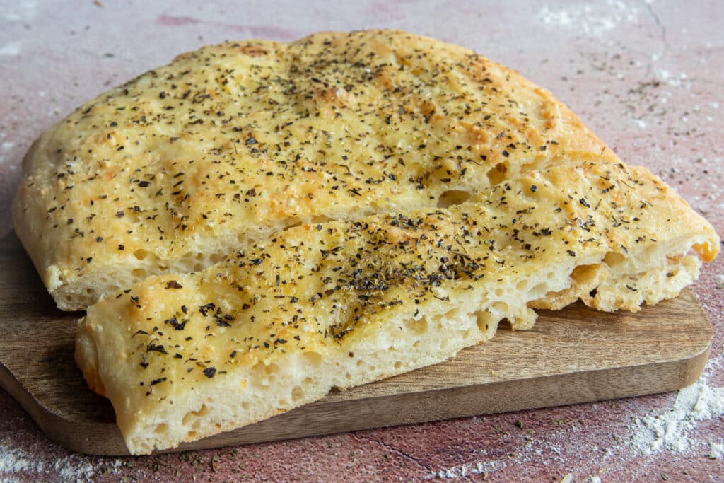 Two slices of focaccia on a wooden board.