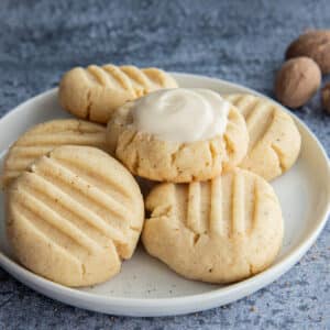 Five nutmeg butter cookies on a white plate.