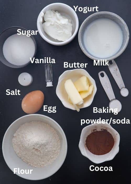 Ingredients to make chocolate donuts in separate bowls.