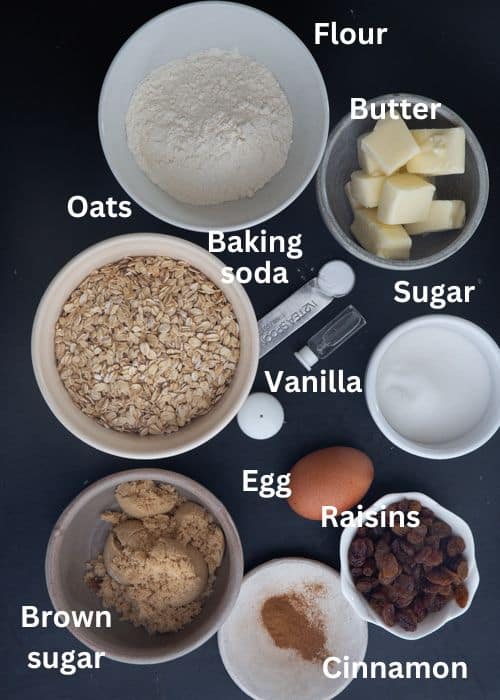Ingredients to make oatmeal raisin cookies in separate bowls.