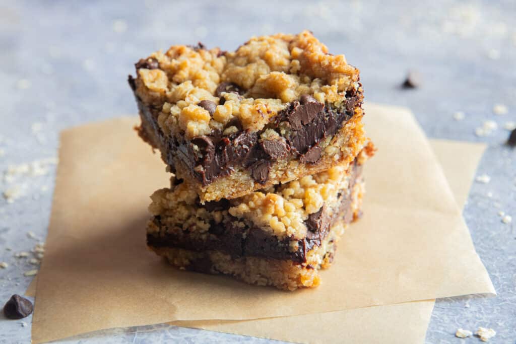 Two Double chocolate oatmeal bars on two square pieces of parchment paper.