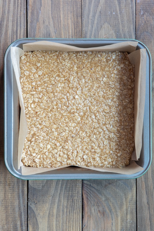Oat mix spread evenly in a square pan on parchment paper.