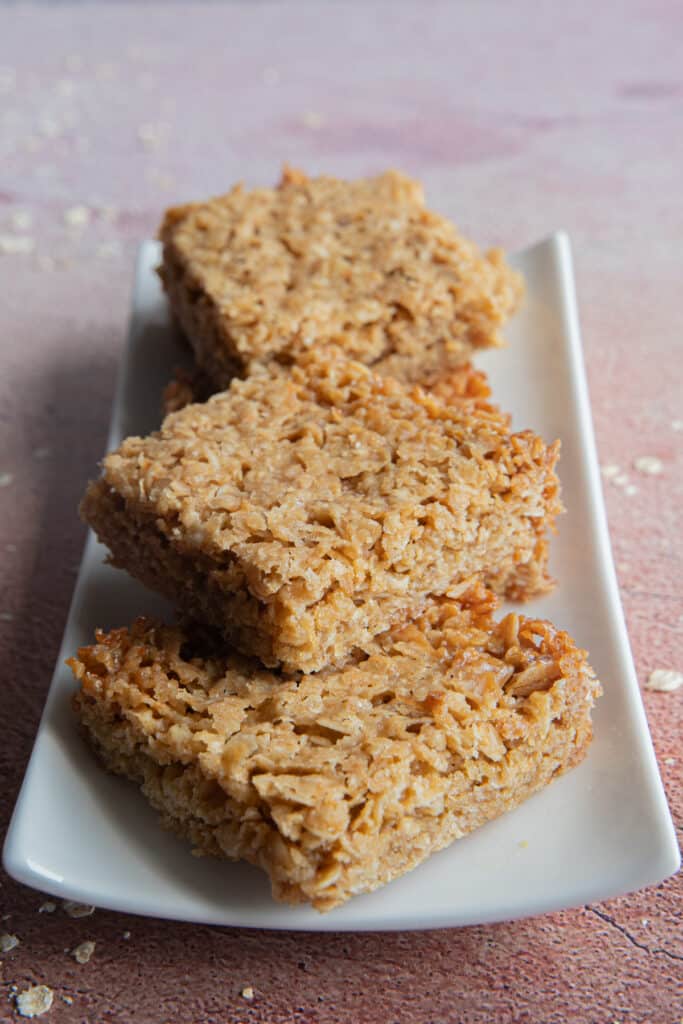 Four flapjack squares on a rectangular white plate.