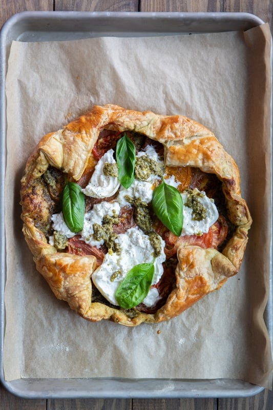 Burrata and basil leaves added to the heirloom tomato galette.