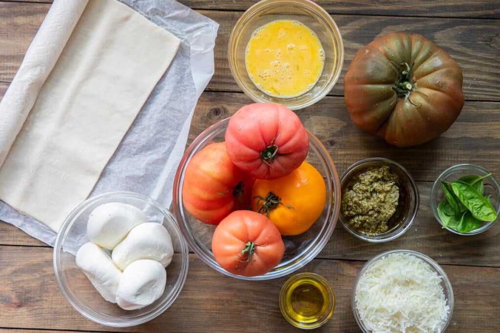 Ingredients to make heirloom tomato galette in separate bowls.