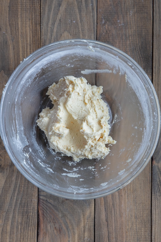 Orange butter cookie dough chilled in a mixing bowl.