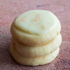 Three orange butter cookies stacked.
