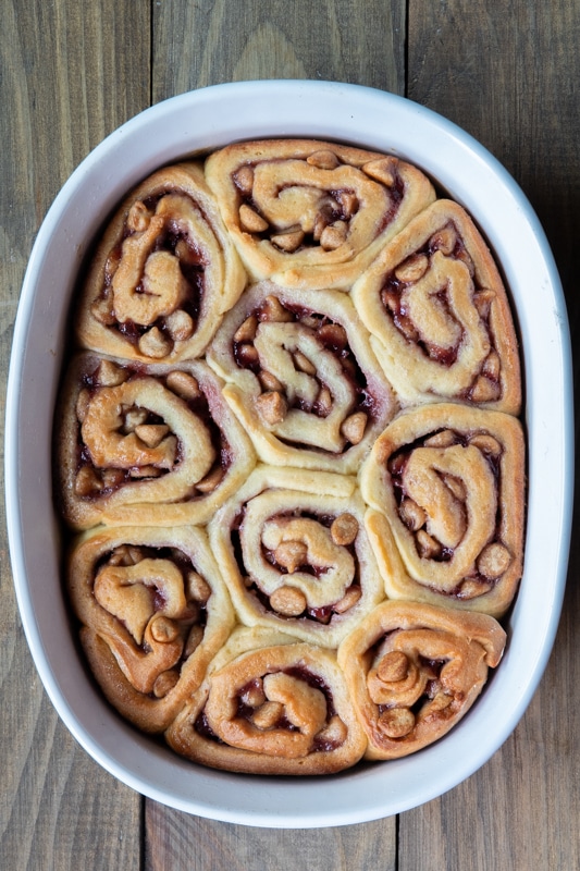 Baked peanut butter cinnamon rolls in a white baking dish.