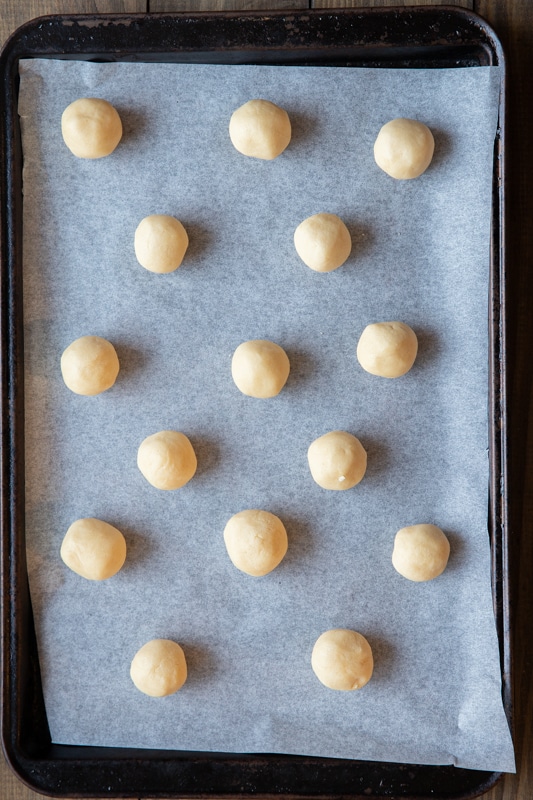 The dough rolled into balls on a cookie sheet.