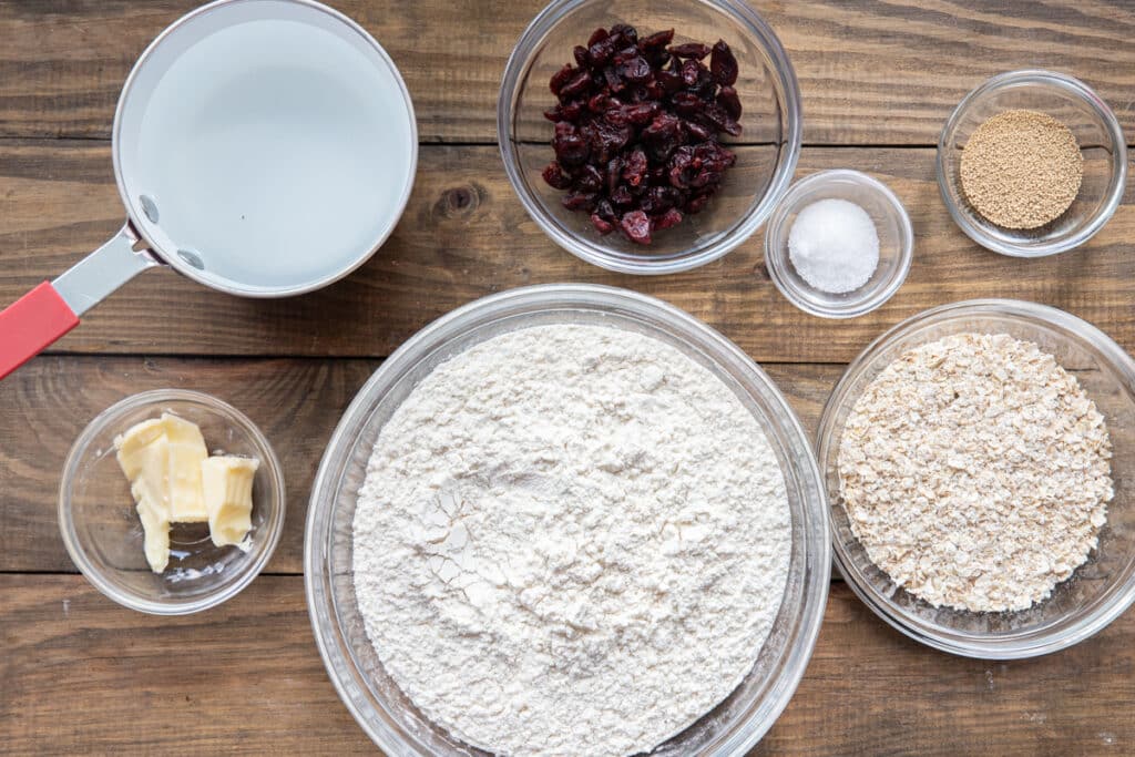 Ingredients to make cranberry and oat bread in separate bowls.