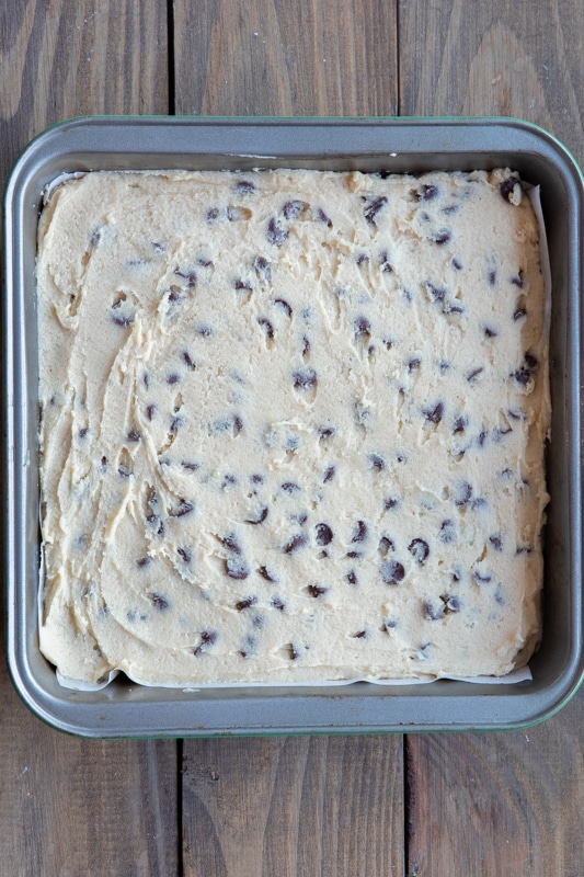 Cookie dough mix spread on top of the brownie mix in the baking pan.